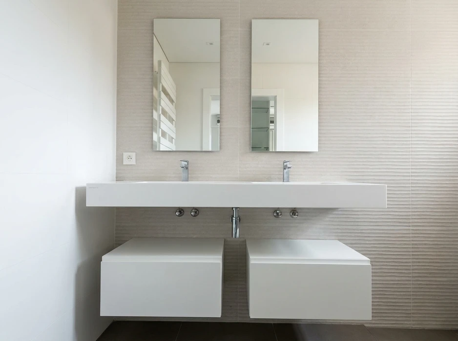 Salle de bains moderne épurée, double vasque suspendue en solid surface blanc mat, deux mitigeurs chromés col de cygne, deux miroirs rectangulaires sans cadre