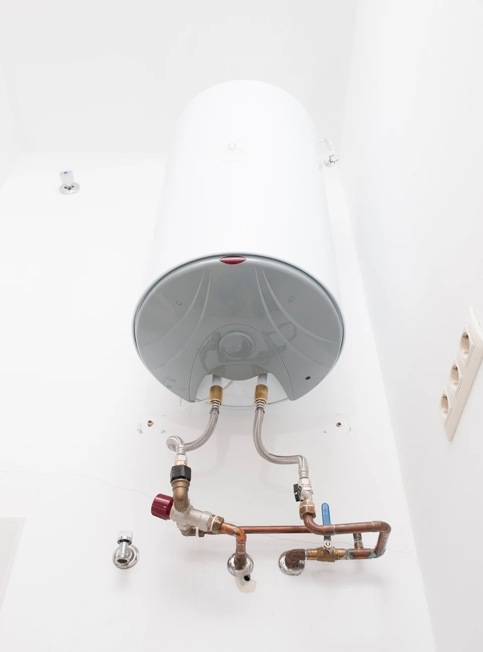 Photographie professionnelle d'un ballon thermodynamique installé dans un intérieur résidentiel (cuisine, garage ou buanderie), montrant l'appareil complet avec sa carrosserie blanche ou noire, entouré d'un environnement domestique neutre. Le ballon doit être clairement identifiable et bien mis en lumière, avec suffisamment de contexte pour montrer qu'il s'agit d'une installation intérieure. L'image doit transmettre l'idée d'une solution technologique performante et moderne pour la production d'eau chaude sanitaire.