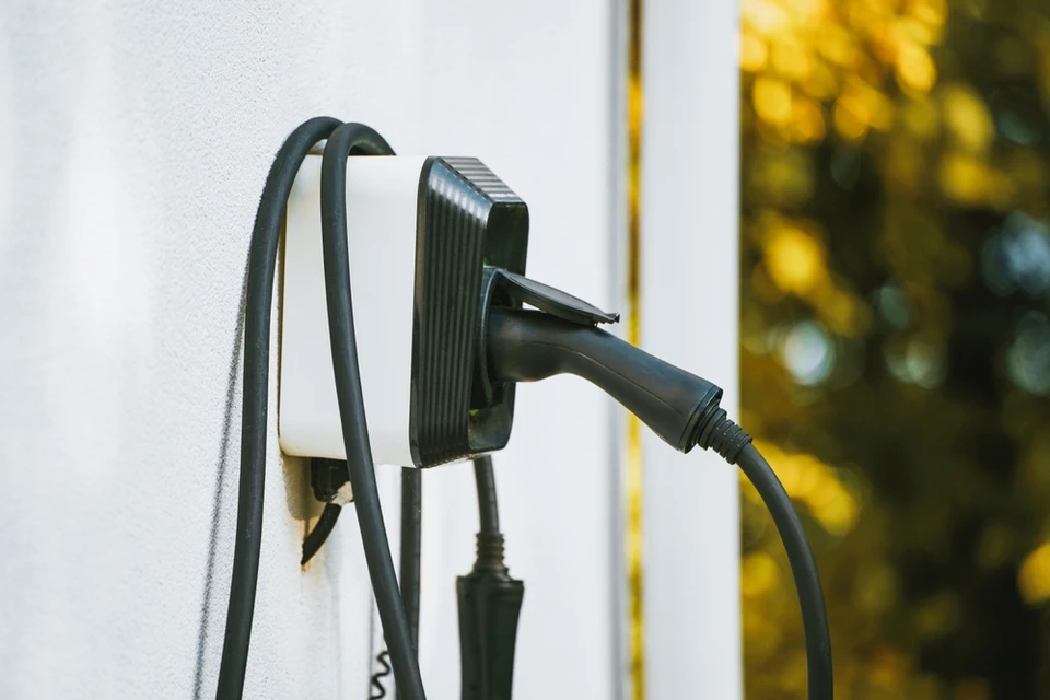 La voiture hybride EV véhicule électrique générique est chargée d'un placard sur une maison d'habitation moderne contemporaine